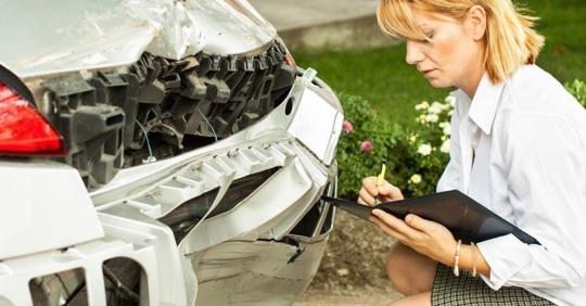 woman looking at car accident evidence